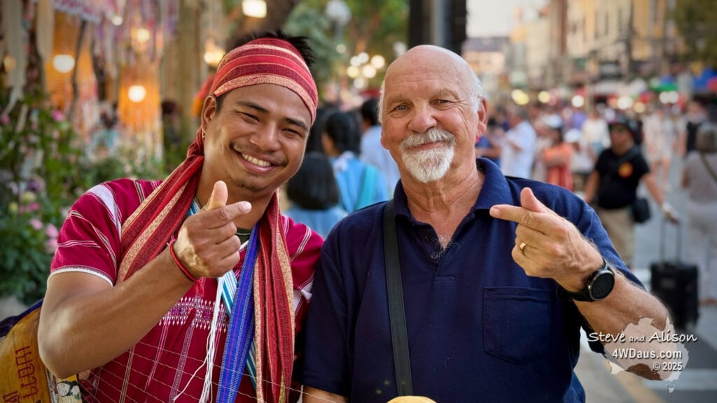 Two men posing for a picture in a crowded city